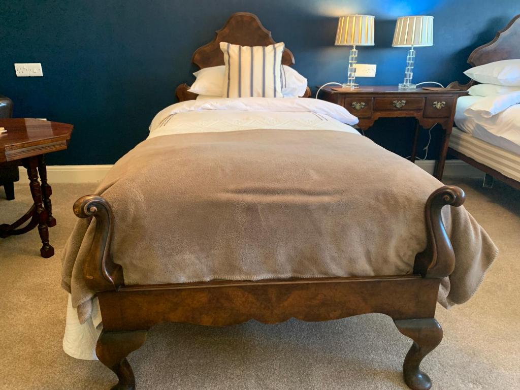 a large bed in a bedroom with two tables at The Coast Yard B & B and Garden Chalets in Selsey