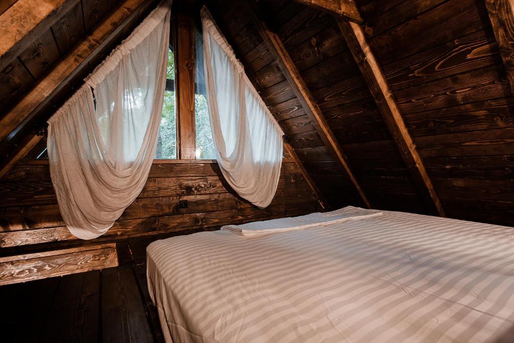 a bed in a wooden room with a window at Black River in Kolašin
