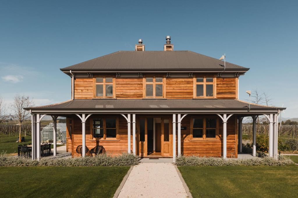 a large wooden house with a gambrel roof at Misty Cove Homestead in Renwick