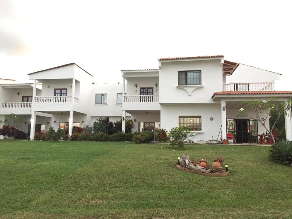 una gran casa blanca con gallinas en el patio en Jardin El Rompio Casa 35, en Los Santos