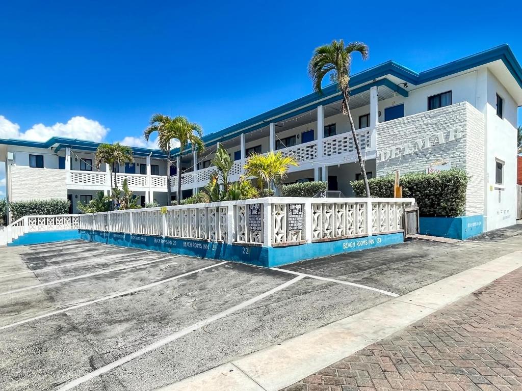 un edificio blanco con una valla blanca y palmeras en The Delmar en Hollywood