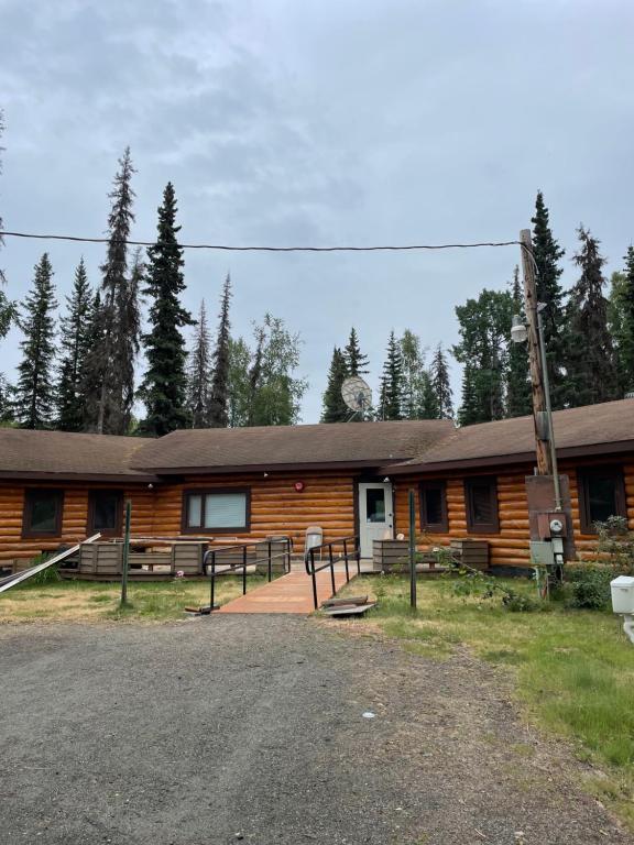 a log cabin with a parking lot in front of it at Soldotna Lodge in Soldotna