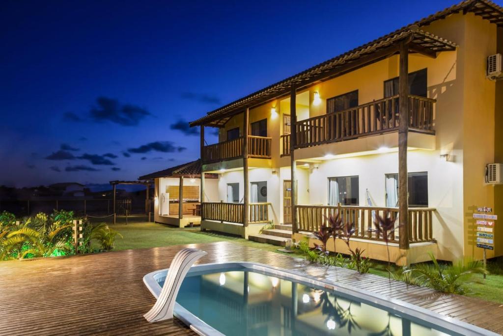 une villa avec une piscine la nuit dans l'établissement Camboa Village, à Barra Grande
