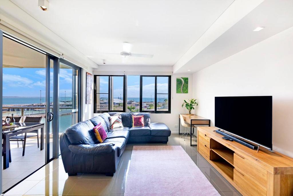 a living room with a couch and a flat screen tv at Darwin Waterfront Lagoon Hideaway with Sea Views in Darwin