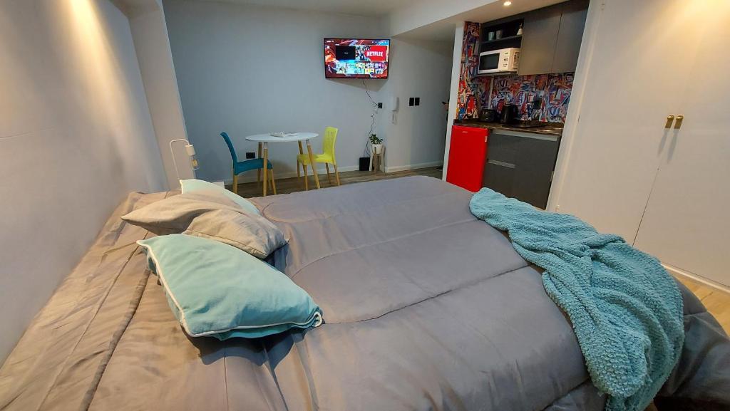 duże łóżko w pokoju z kuchnią w obiekcie Plan Córdoba Centro w Córdobie