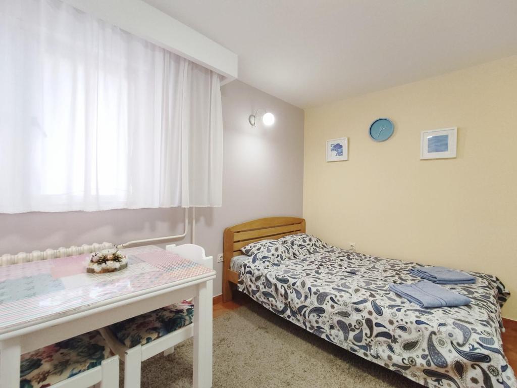 um pequeno quarto com uma cama e uma mesa em Ada Belgrade Apartment em Belgrado