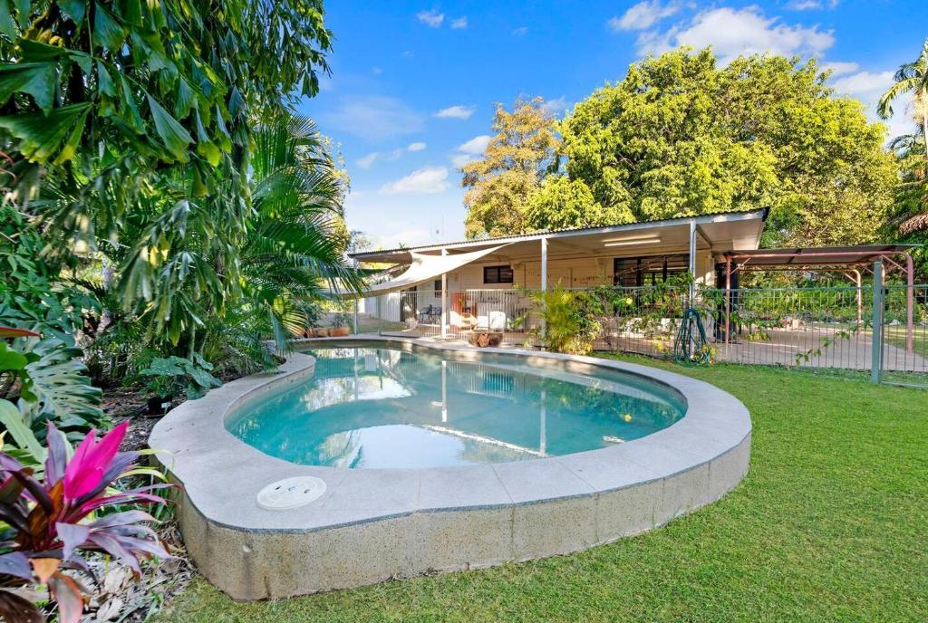 a swimming pool in the yard of a house at Tropical Tranquillity - Spacious Poolside Cottage in Nightcliff