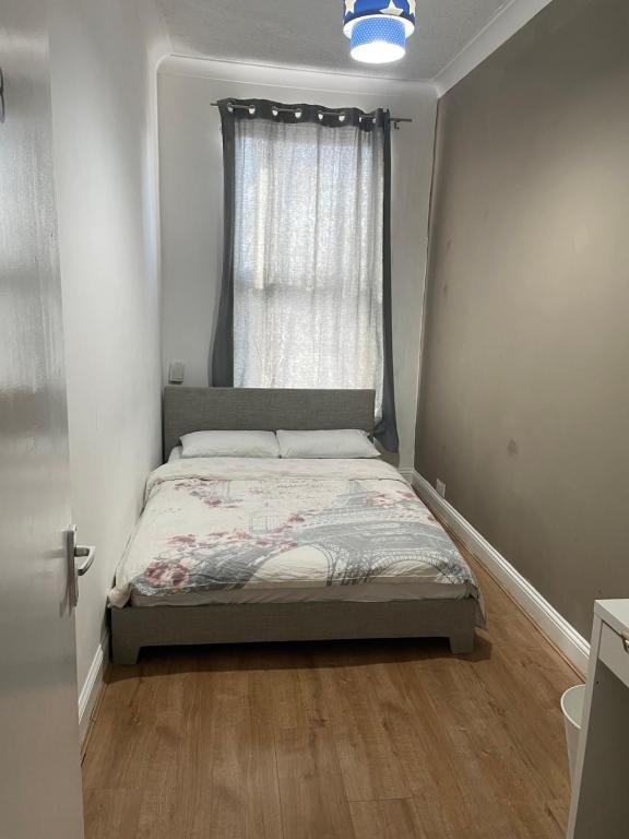 a small bedroom with a bed with a window at 03 Bedroom Apartment-Self Check in in London