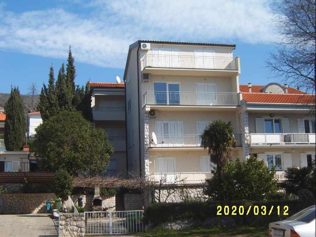 a white building with a red roof at Apartments by the sea Dramalj, Crikvenica - 5596 in Dramalj