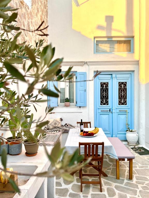 a patio with a table and chairs and a blue door at Aetheria traditional house in Koskinou