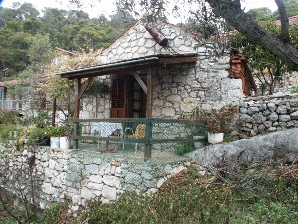 uma casa de pedra com um banco à frente em Apartments by the sea Babine Kuce, Mljet - 610 em Goveđari