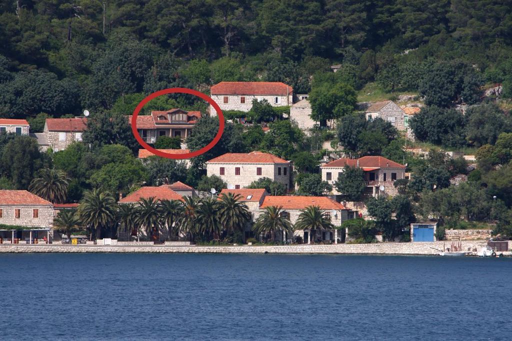 ein roter Kreis auf einem Haus in der Nähe des Wassers in der Unterkunft Apartments by the sea Babine Kuce, Mljet - 611 in Goveđari