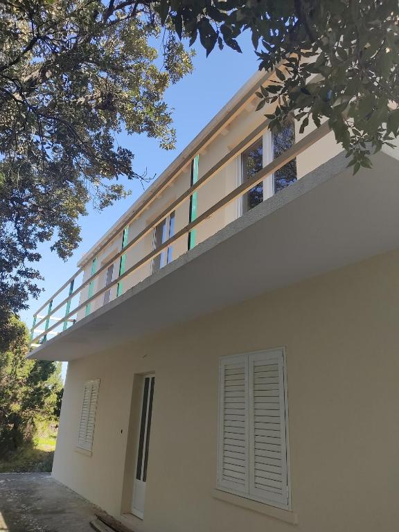 a white building with a balcony on top of it at Seaside secluded apartments Cove Blaca, Mljet - 615 in Saplunara
