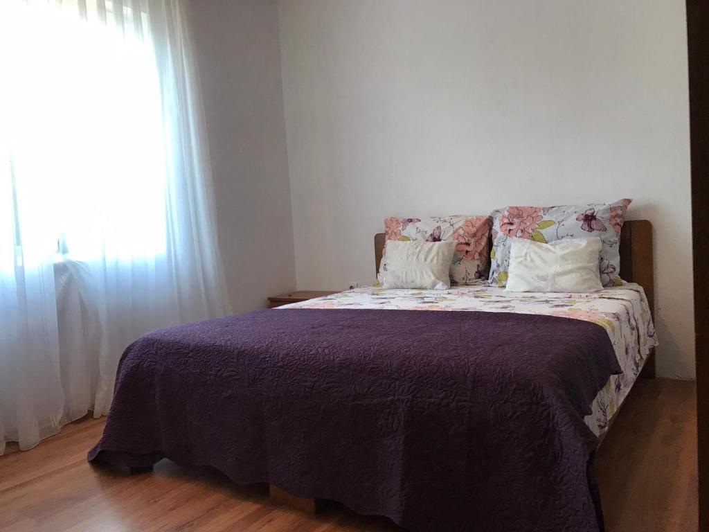 a bedroom with a bed with a purple blanket and a window at Seaside secluded apartments Cove Blaca, Mljet - 615 in Saplunara