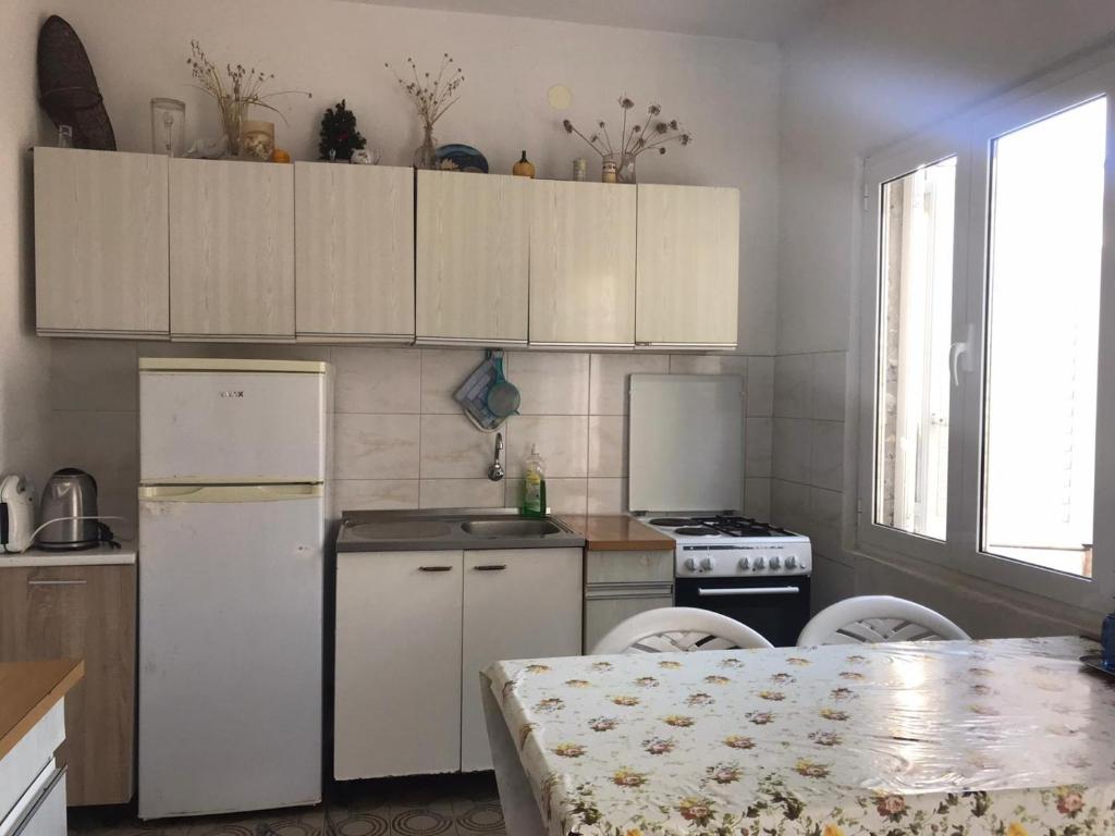 a kitchen with white cabinets and a stove and a table at Seaside secluded apartments Cove Blaca, Mljet - 615 in Saplunara