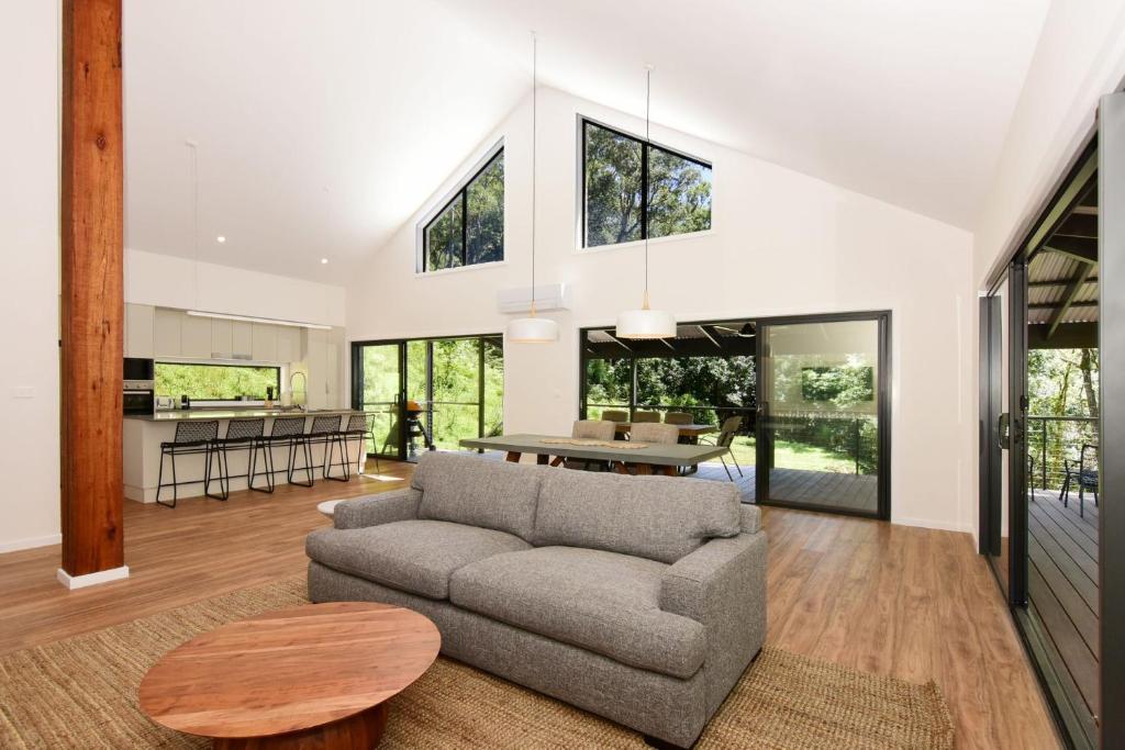sala de estar con sofá y mesa en Rainforest River Retreat Kangaroo Valley, en Upper Kangaroo River