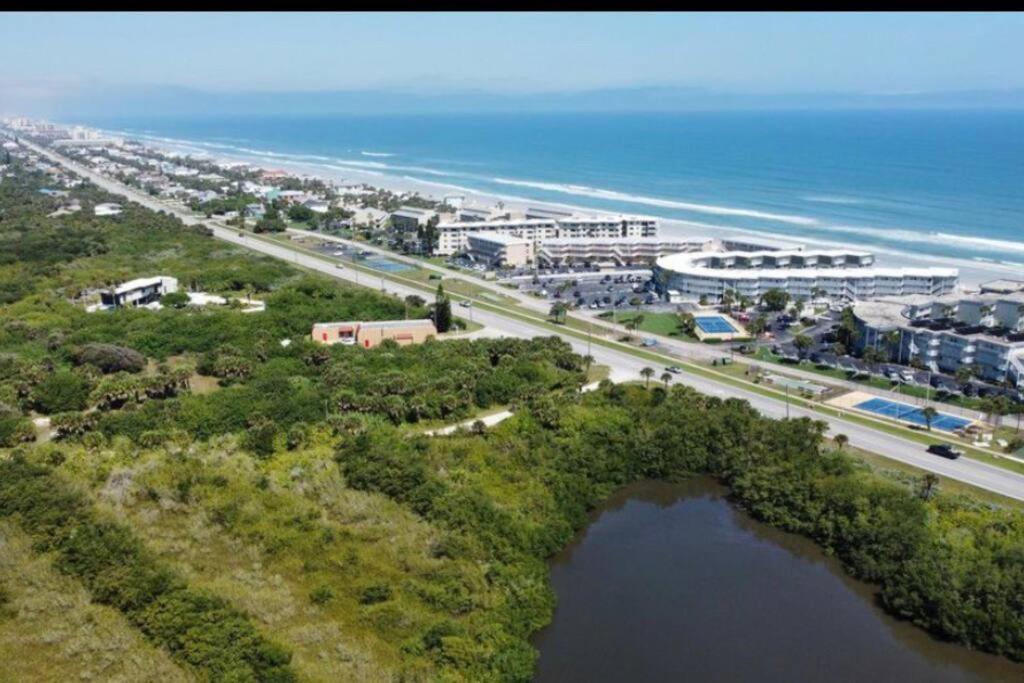 an aerial view of a city and a road next to the ocean at Lovely & Cozy 3 bedroom with pool in New Smyrna Beach