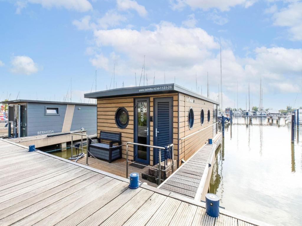 a small house on a dock on the water at Comfortable houseboat in Marina Volendam in Volendam