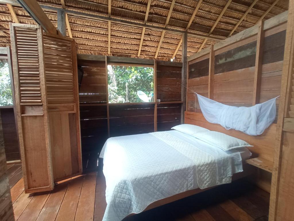 1 dormitorio con 1 cama en una habitación con ventanas en Casa Azul Reserva Amazonica, en Leticia