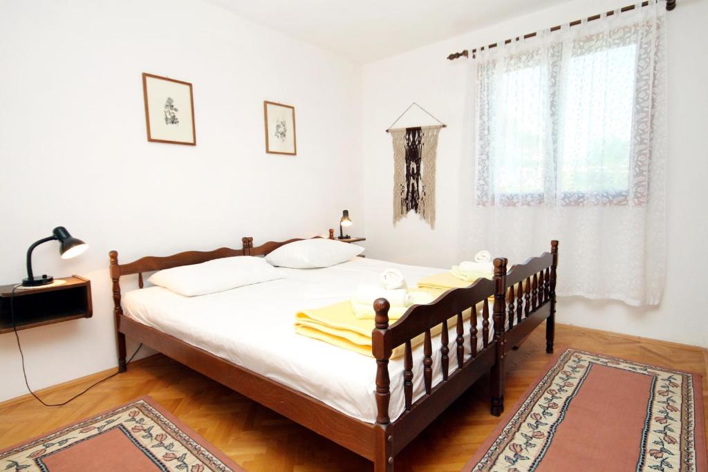 sypialnia z łóżkiem z białą pościelą i dywanem w obiekcie Apartment Zavala 594b w mieście Jelsa