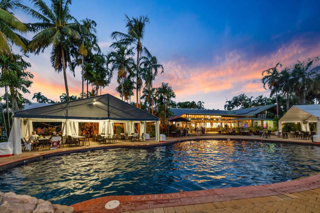 uma piscina num resort com um pôr-do-sol em Darwin FreeSpirit Resort em Darwin
