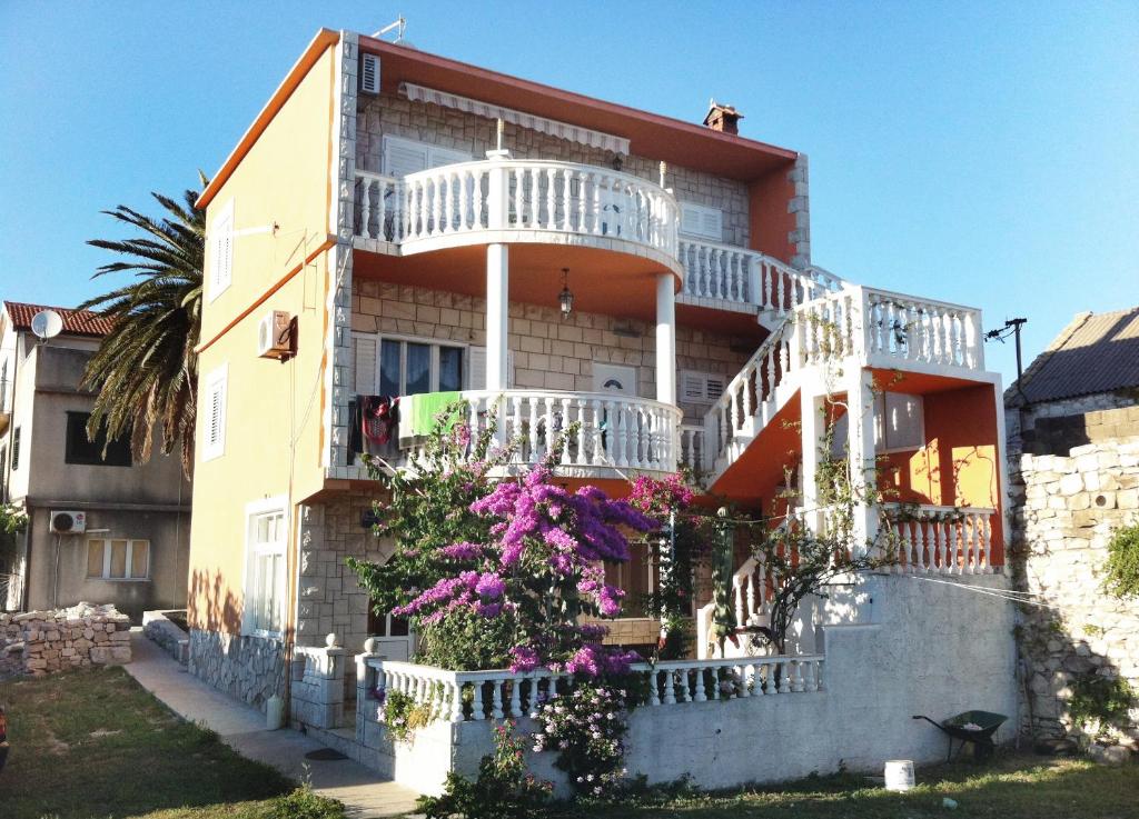 ein Haus mit einem weißen Balkon und lila Blumen in der Unterkunft Apartments by the sea Sucuraj, Hvar - 590 in Sućuraj