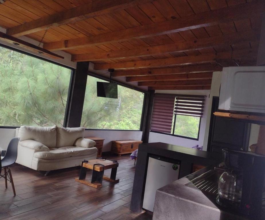 a living room with a couch and a tv at Mazamitla Pinos del Rio in Mazamitla