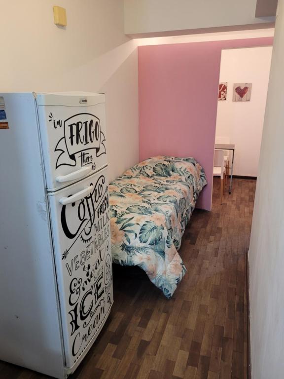 a room with a bed next to a refrigerator at Departamento Calle San Martin ( Microcentro) in San Miguel de Tucumán