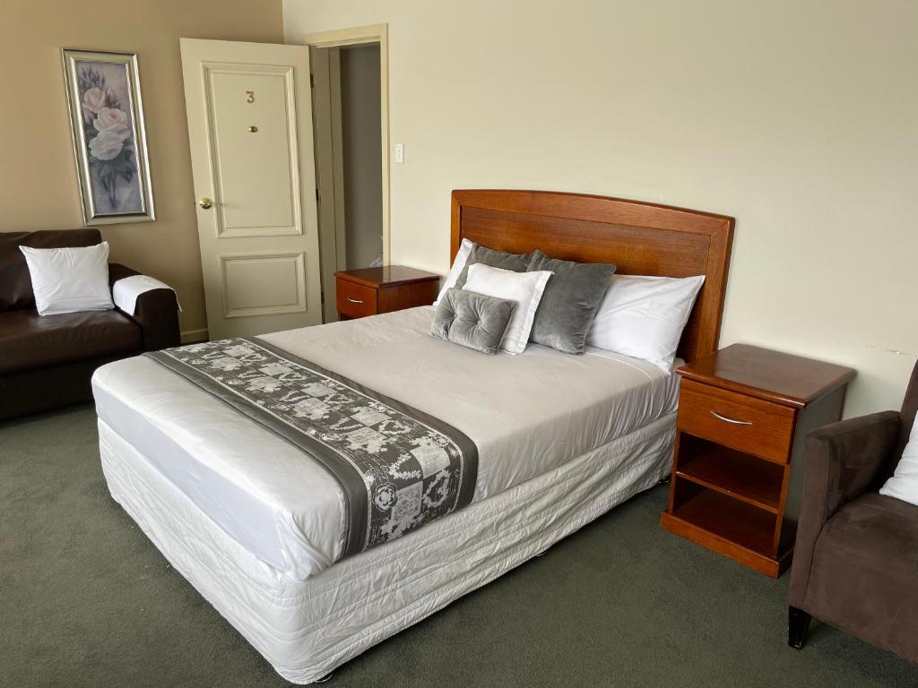 een slaapkamer met een groot bed en een bank bij 503 On Princes Drive Motel in Morwell