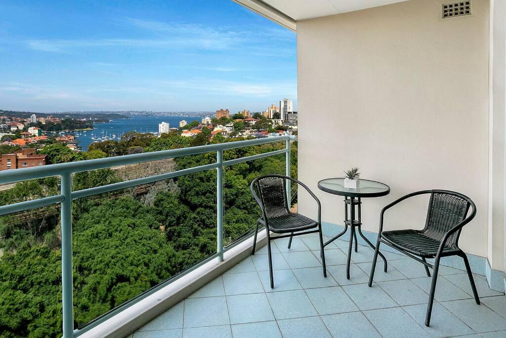 雪梨的住宿－ALF49-Huge 2BR Penthouse Style, Great Water Views，阳台配有2把椅子和1张桌子,享有风景。