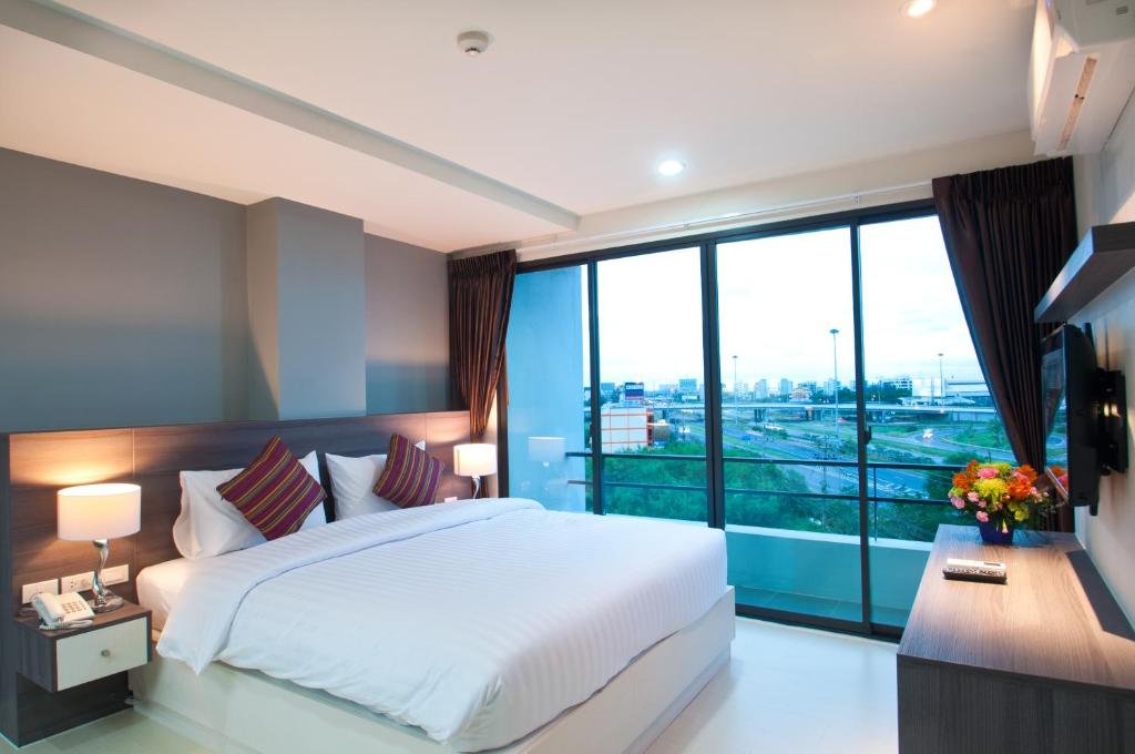 a bedroom with a large bed and a large window at VC Residence - Chon Buri in Chon Buri