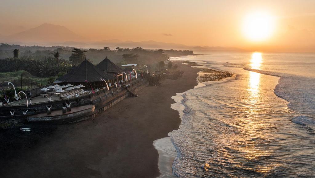 um grupo de barcos na praia ao pôr do sol em Desa Swan Villas & SPA, Keramas em Keramas