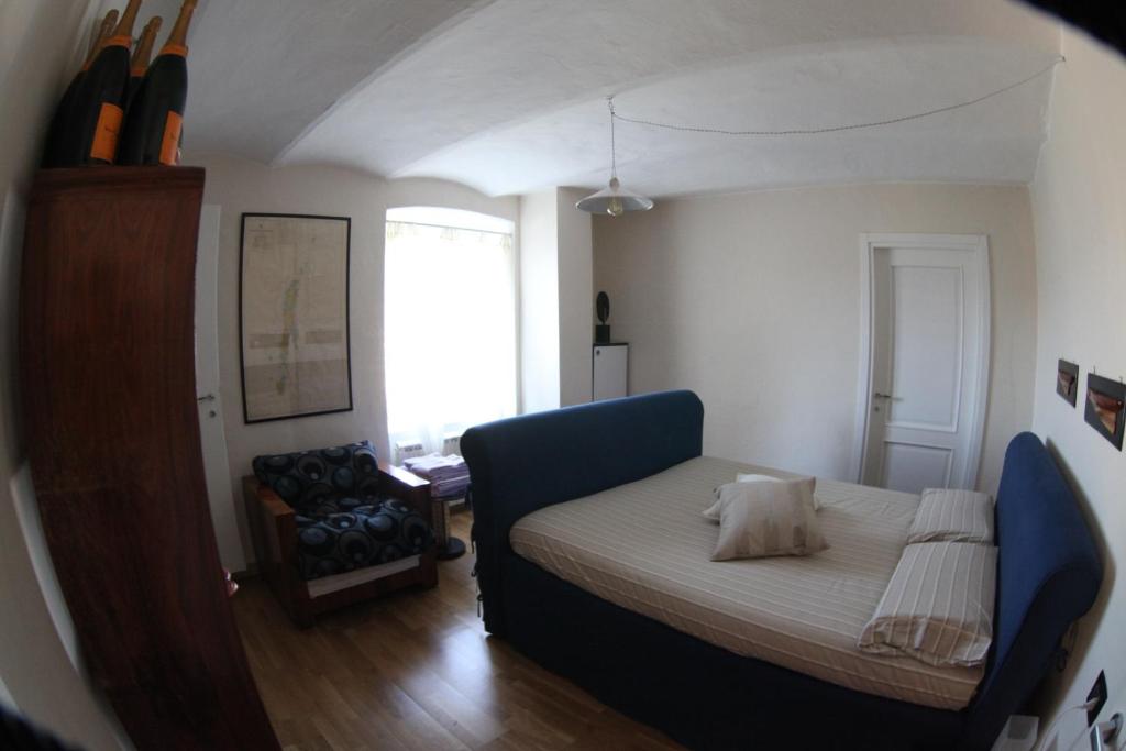 a small bedroom with a bed and a chair at BBQ Lodge in Camogli