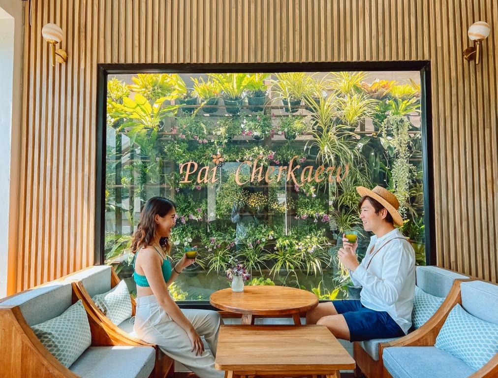 a man and woman sitting at a table in a restaurant at Pai Cherkaew Boutique House in Pai
