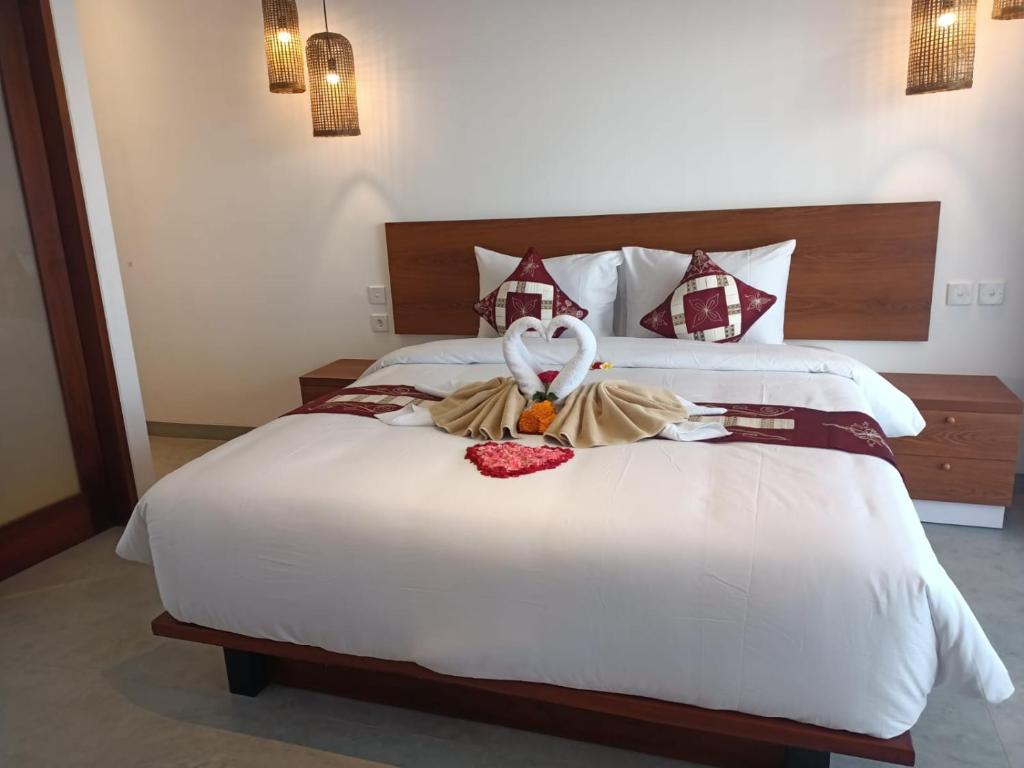 a hotel room with a bed with a swan on it at The Kd Suites & Coffee Shop in Munggu