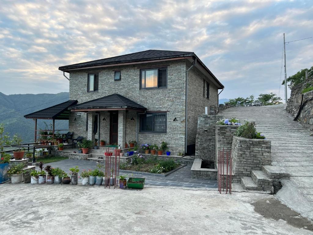 una casa en la cima de una colina con plantas en The North Face Inn's Homestay en Pokhara