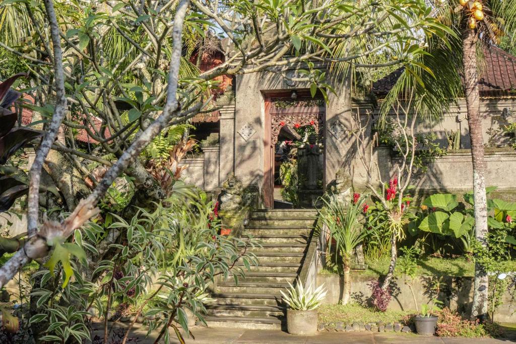 une maison avec des escaliers menant à une porte dans l'établissement Bramasa Ubud Guest House, à Ubud