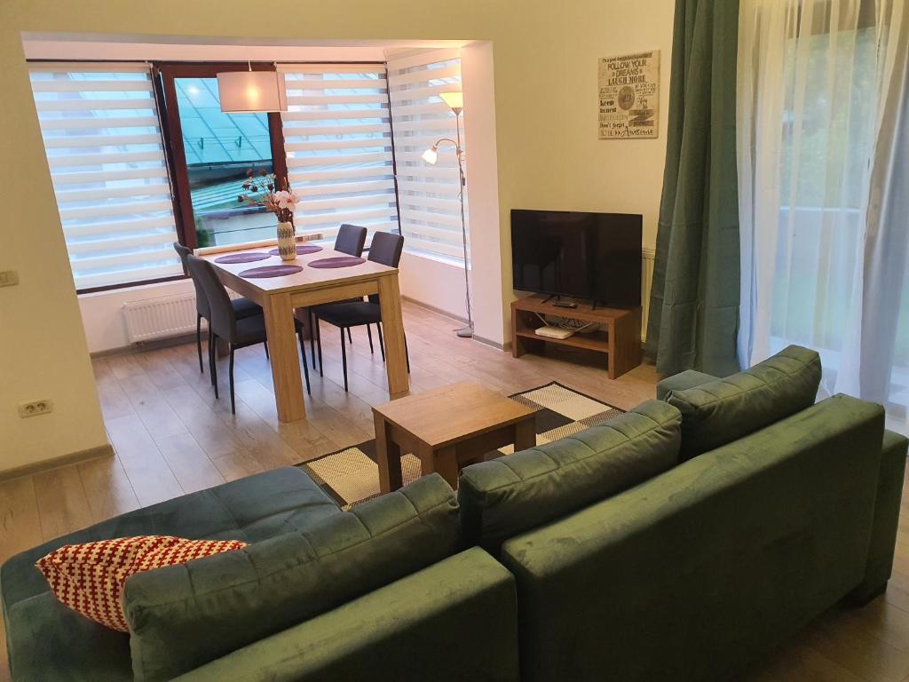 ein Wohnzimmer mit einem Sofa und einem Tisch in der Unterkunft AOSTA VALLEY SINAIA in Sinaia