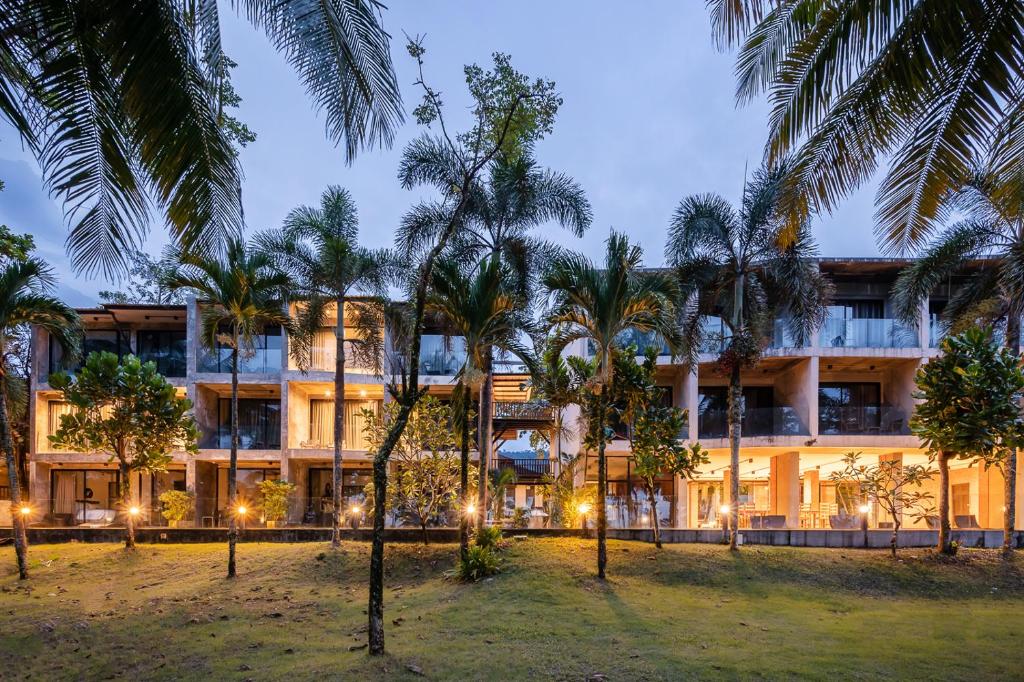 a building with palm trees in front of it at Kokotel Khao Lak Lighthouse in Khao Lak
