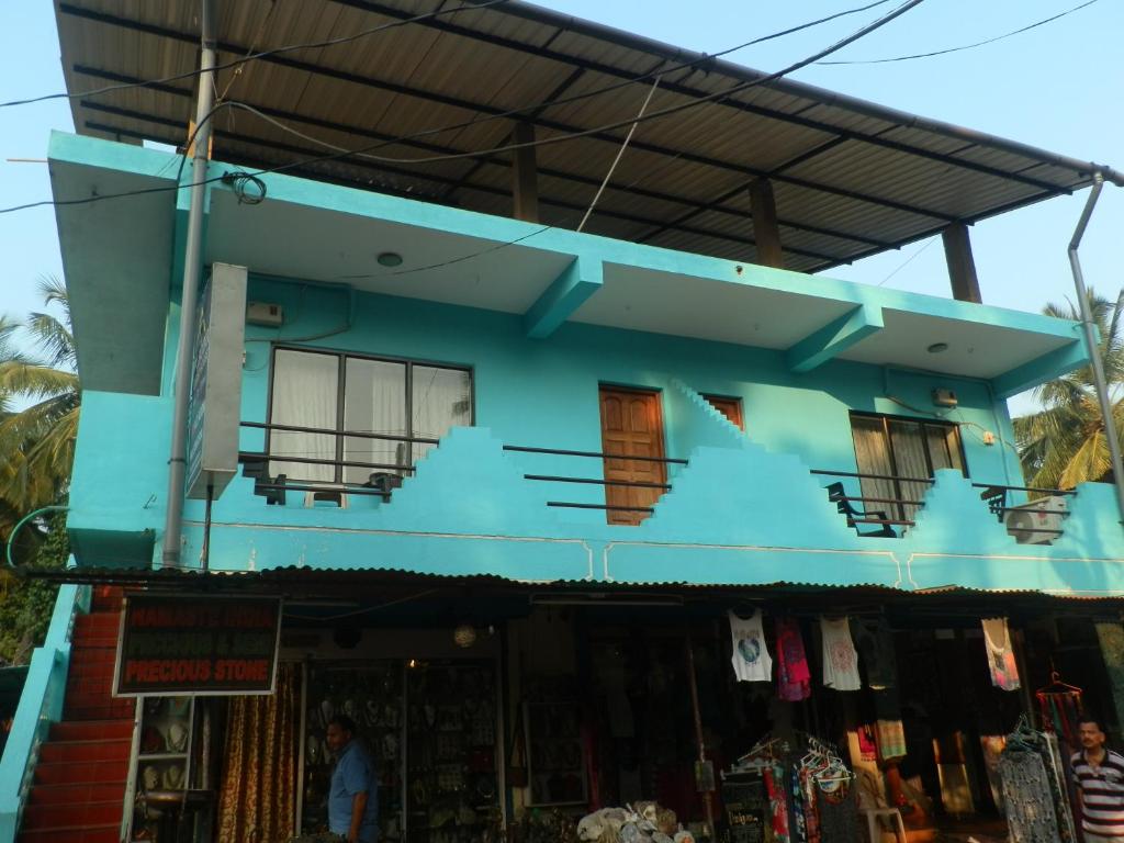a blue building with a shop in front of it at Aldrin Guest House in Palolem