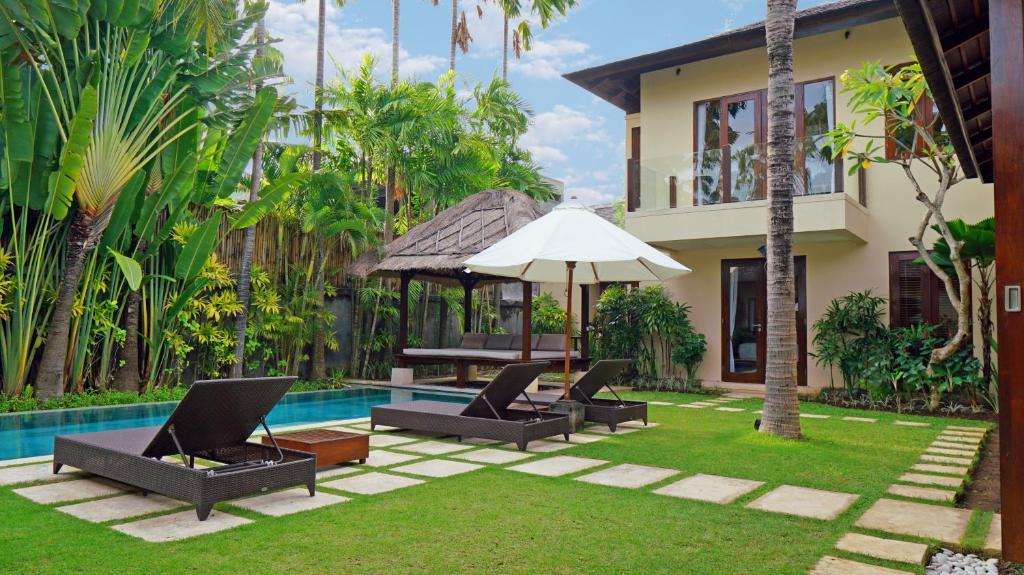 a villa with a swimming pool and a house at The New Villa Suar in Seminyak