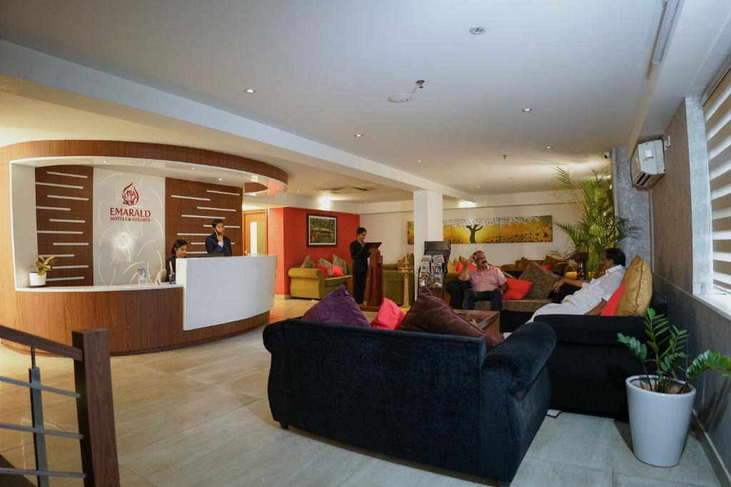 eine Lobby mit Sofas und Personen in einem Zimmer in der Unterkunft Emarald Hotel Calicut in Kozhikode