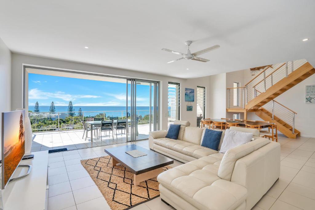 a living room with a view of the ocean at Rainbow Sea Resort in Rainbow Beach