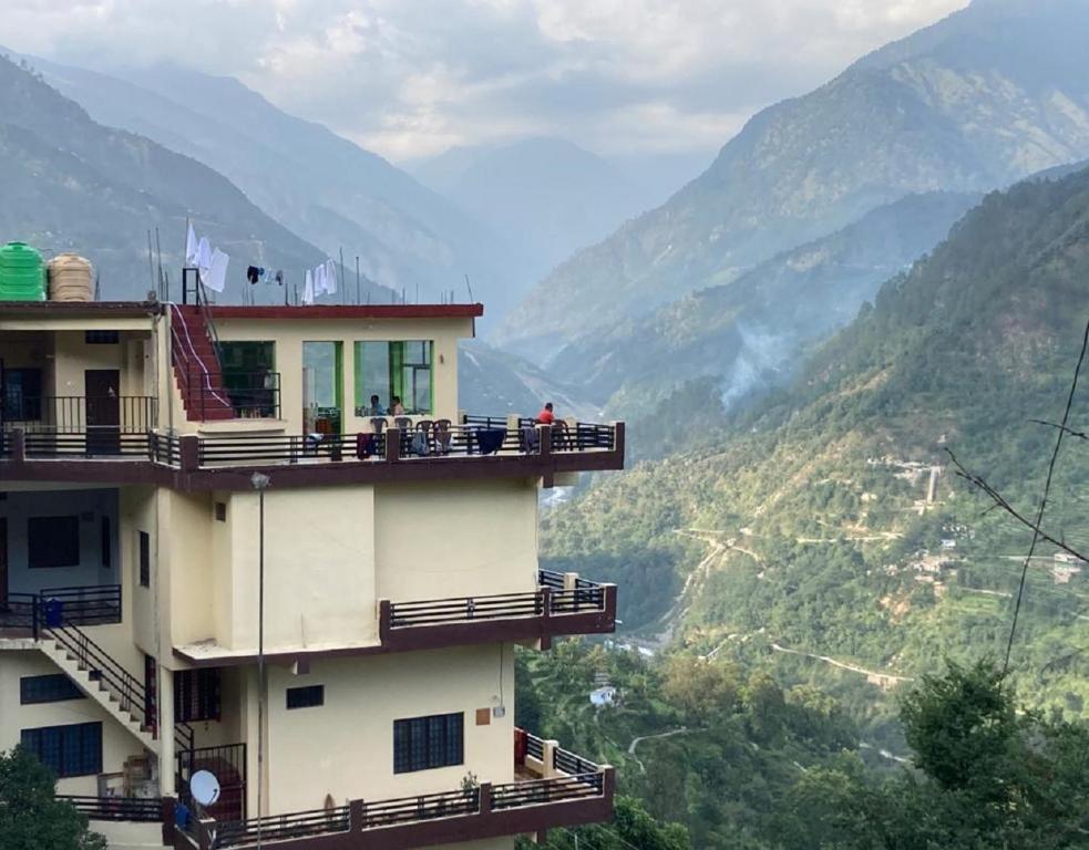 een gebouw met balkons en uitzicht op de bergen bij Amardeep Homestay by StayApart in Ukhimath