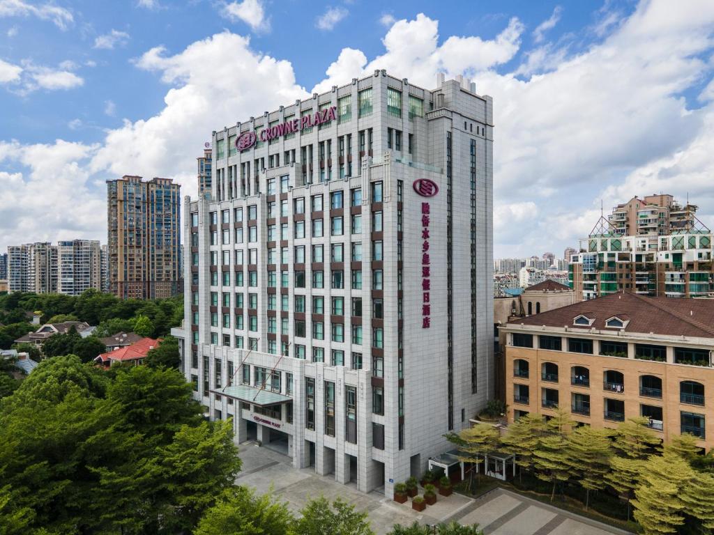 Crowne Plaza Fuzhou South, an IHG Hotel في فوتشو: مبنى أبيض طويل عليه علامة