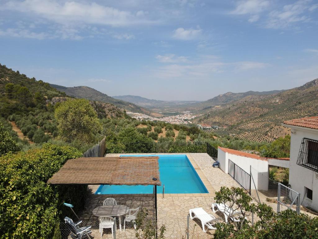 a villa with a swimming pool and mountains in the background at Maison écologique avec piscine in La Puerta de Segura