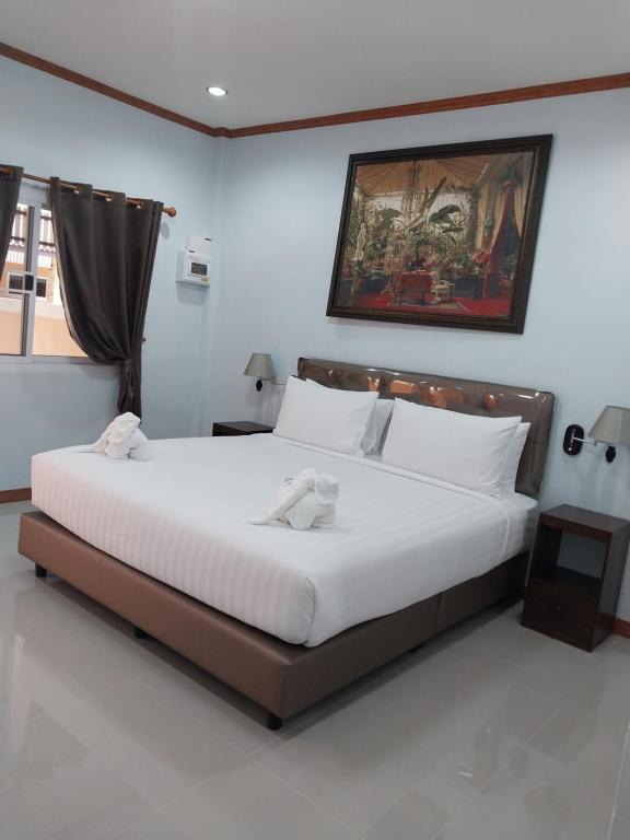 a bedroom with a large bed with two towels on it at Tong Chang Resort in Chumphon