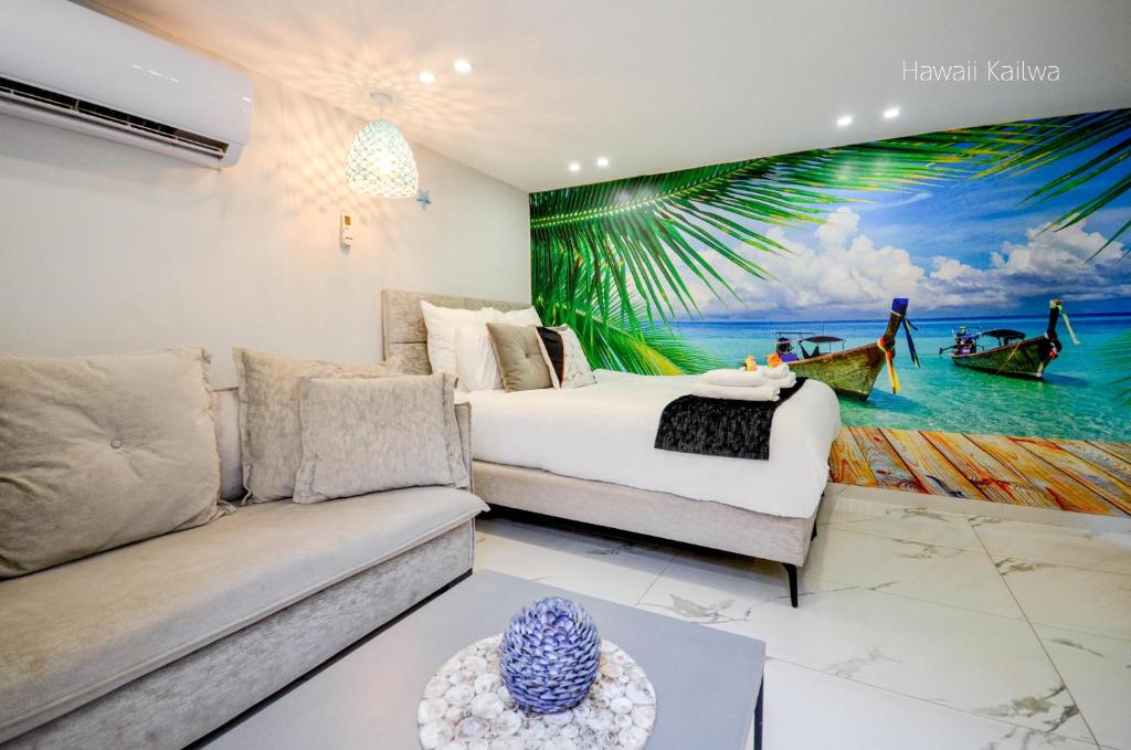 uma sala de estar com um sofá e uma pintura na parede em Yalarent Hawaii Complex Boutique & Garden Hotel Apartments Eilat em Eilat