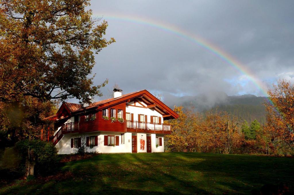 a rainbow over a house on a hill at Relax e natura vicino a Trento in Montagnaga