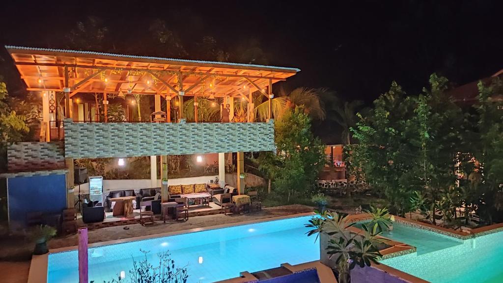 Bunaken Villa Queen's Dive في بوناكن: منزل به حمام سباحة في الليل